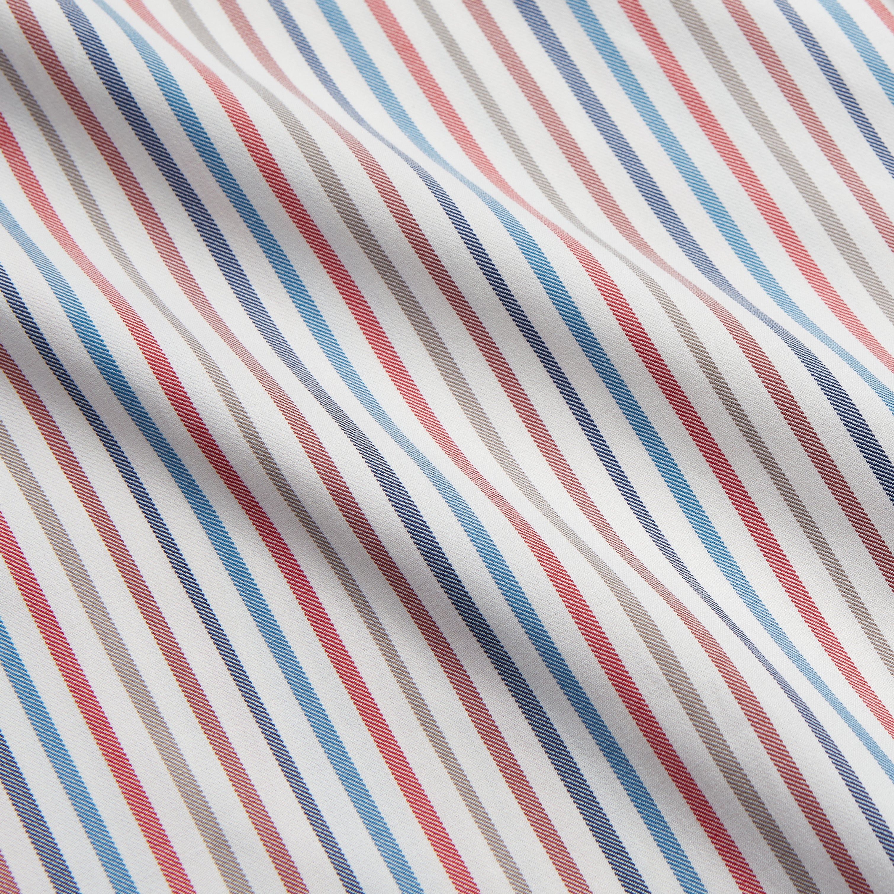 View 4 of product The Turnbull & Asser Burgundy Multi Stripe Tailored Fit Shirt features a Kent collar and 2 button cuffs, with vertical stripes on a light background. The shirt is neatly laid flat on a white surface.