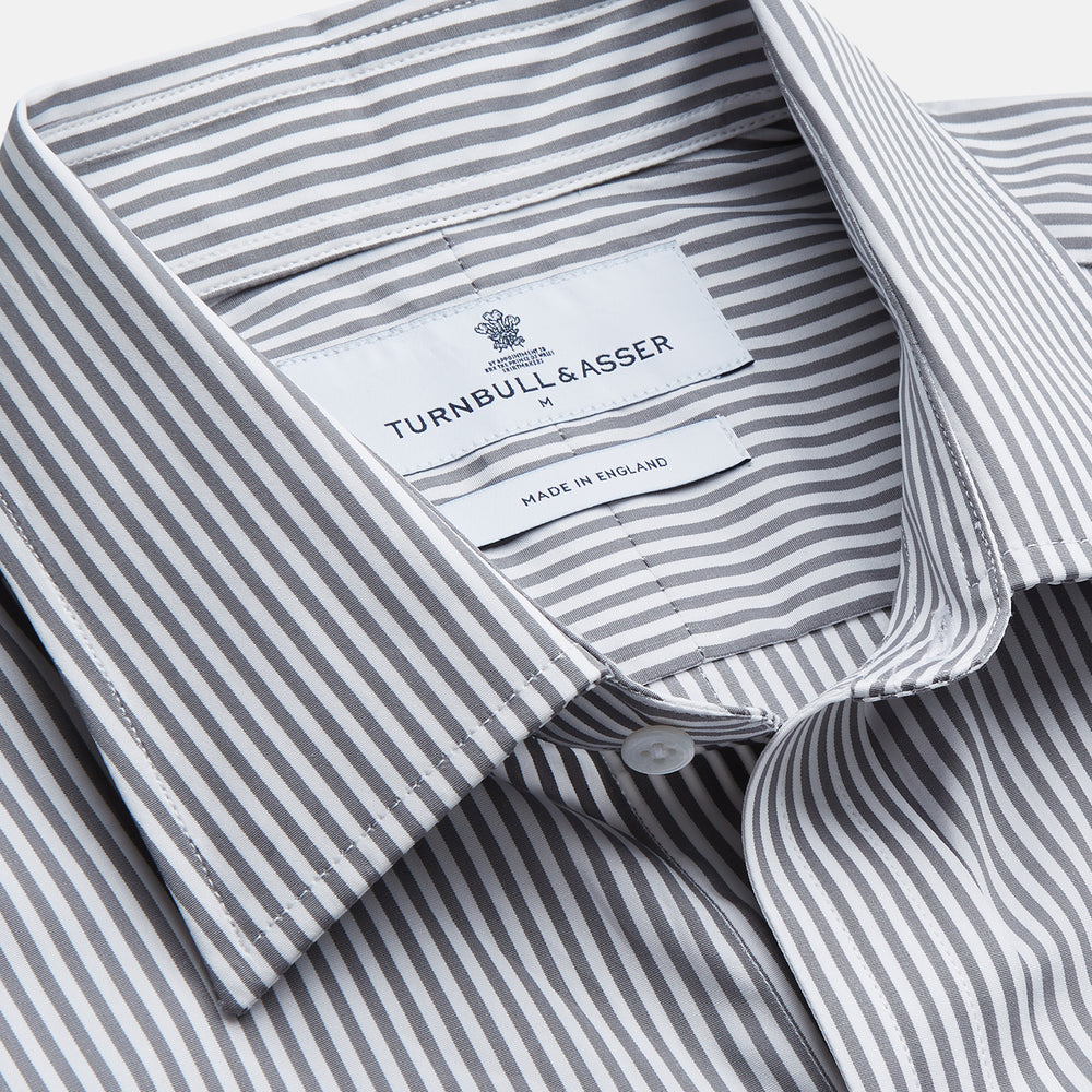 The Turnbull & Asser Grey & White Stripe Weekend Fit Shirt features a Derby collar, 1-button cuffs, and chest pocket—ideal for casual weekends. Shown on a plain white background.