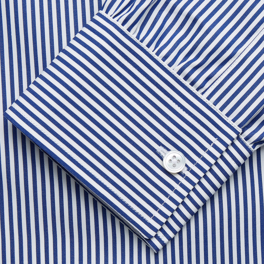 The Turnbull & Asser Navy & White Stripe Weekend Fit Shirt features a Derby collar, 1-button cuffs, front chest pocket, vertical stripes, and white buttons. Displayed flat on a white background.