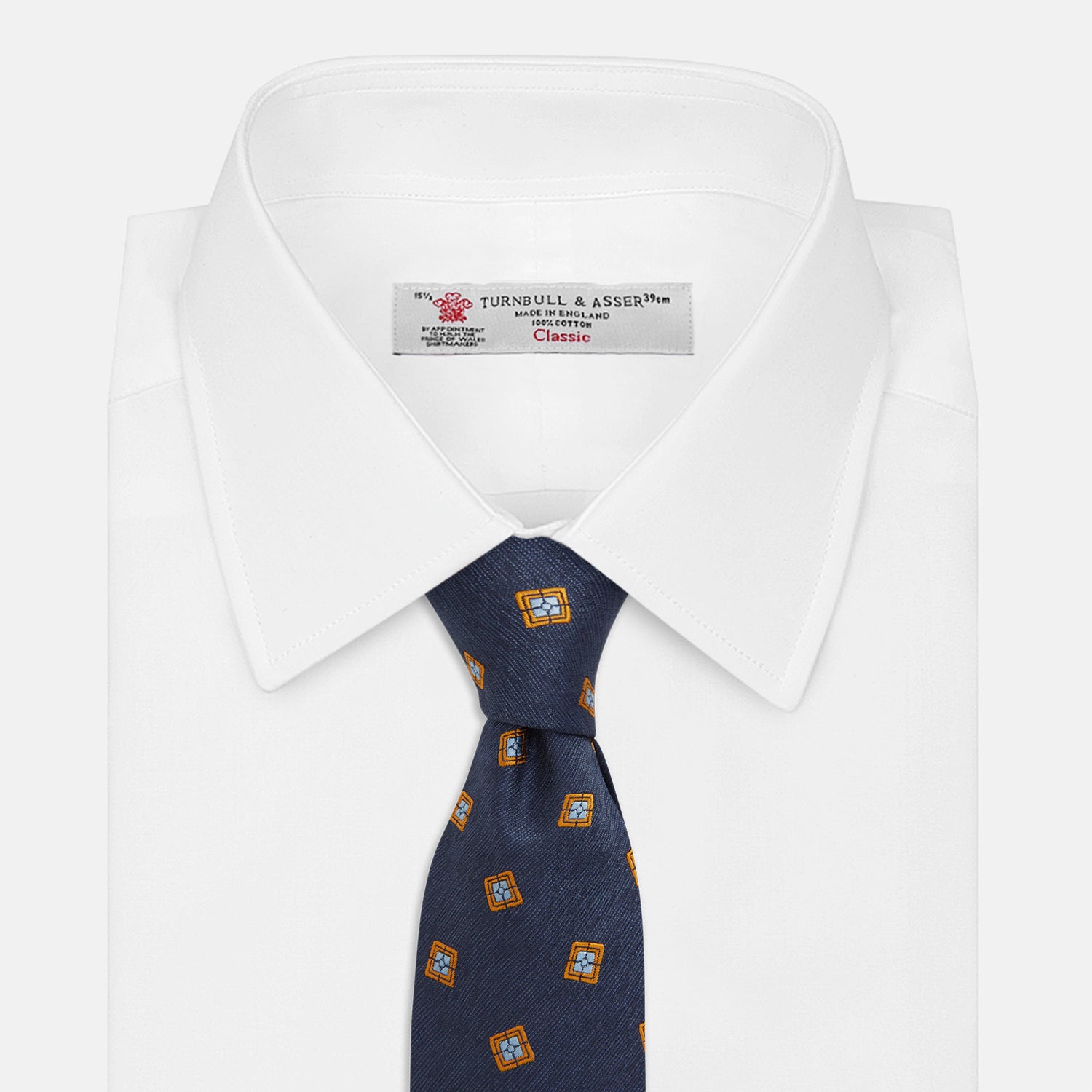 View 2 of product The Turnbull & Asser Orange Multi Geo Silk Tie, featuring a vibrant geometric pattern, is showcased rolled up on a plain white background—an elegant piece from our autumn-winter collection.