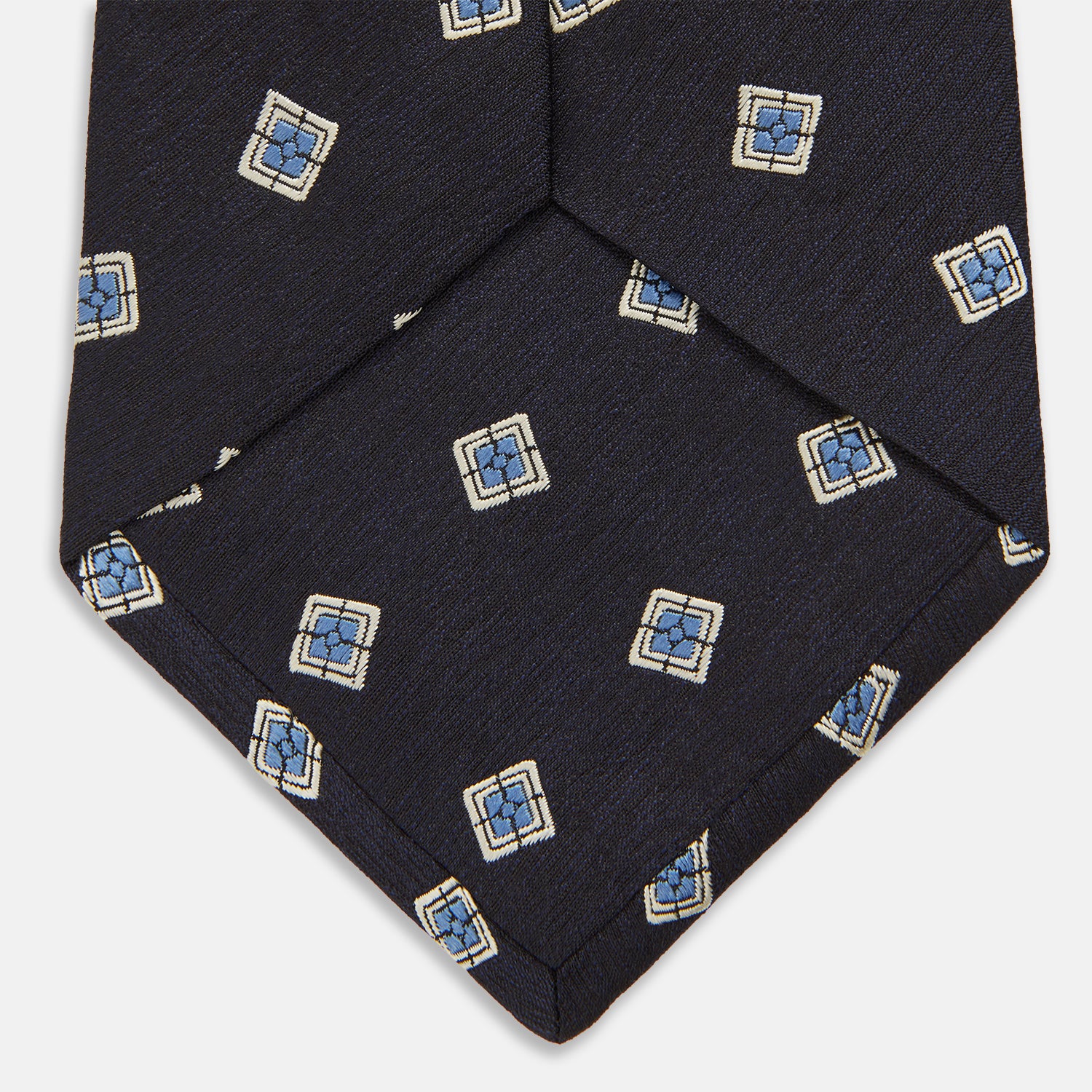 View 4 of product The Turnbull & Asser Navy Multi Geo Silk Tie features a dark navy blue geometric pattern with blue and cream squares—ideal for pairing with bold signature shirts from the autumn-winter collection.