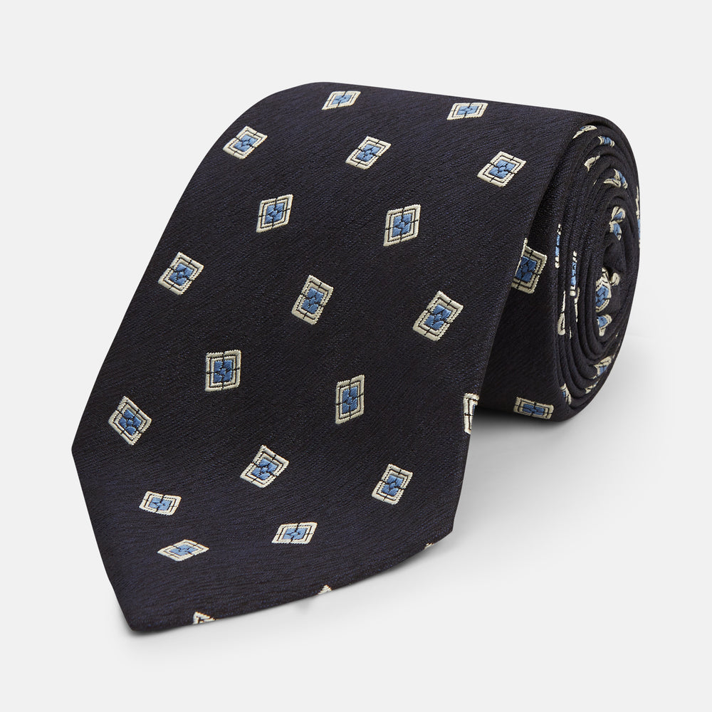 The Turnbull & Asser Navy Multi Geo Silk Tie features a dark navy blue geometric pattern with blue and cream squares—ideal for pairing with bold signature shirts from the autumn-winter collection.
