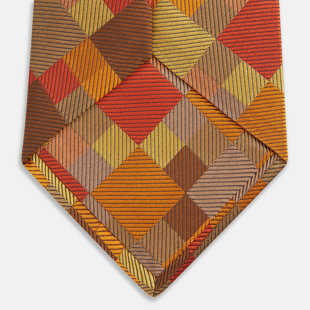 A close up of the Turnbull & Asser Orange Multi Pixel Silk Tie, featuring a refined checked design—ideal for elevating your autumn-winter style.