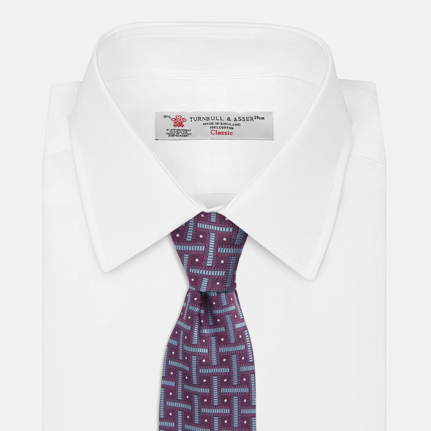 View 2 of product The Turnbull & Asser Purple & Navy Cross Silk Tie features a geometric pattern of intersecting blue lines and white dots—an ideal accessory to elevate formal outfits or complement signature shirts.