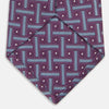 View 4 of product The Turnbull & Asser Purple & Navy Cross Silk Tie features a geometric pattern of intersecting blue lines and white dots—an ideal accessory to elevate formal outfits or complement signature shirts.