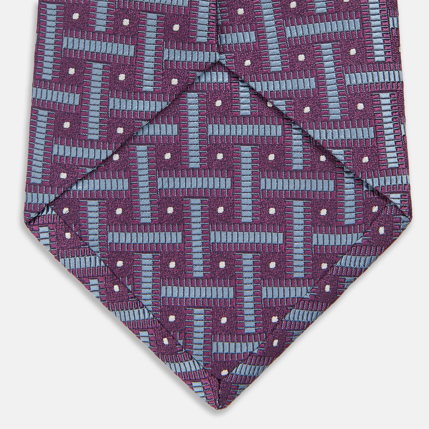 View 4 of product The Turnbull & Asser Purple & Navy Cross Silk Tie features a geometric pattern of intersecting blue lines and white dots—an ideal accessory to elevate formal outfits or complement signature shirts.