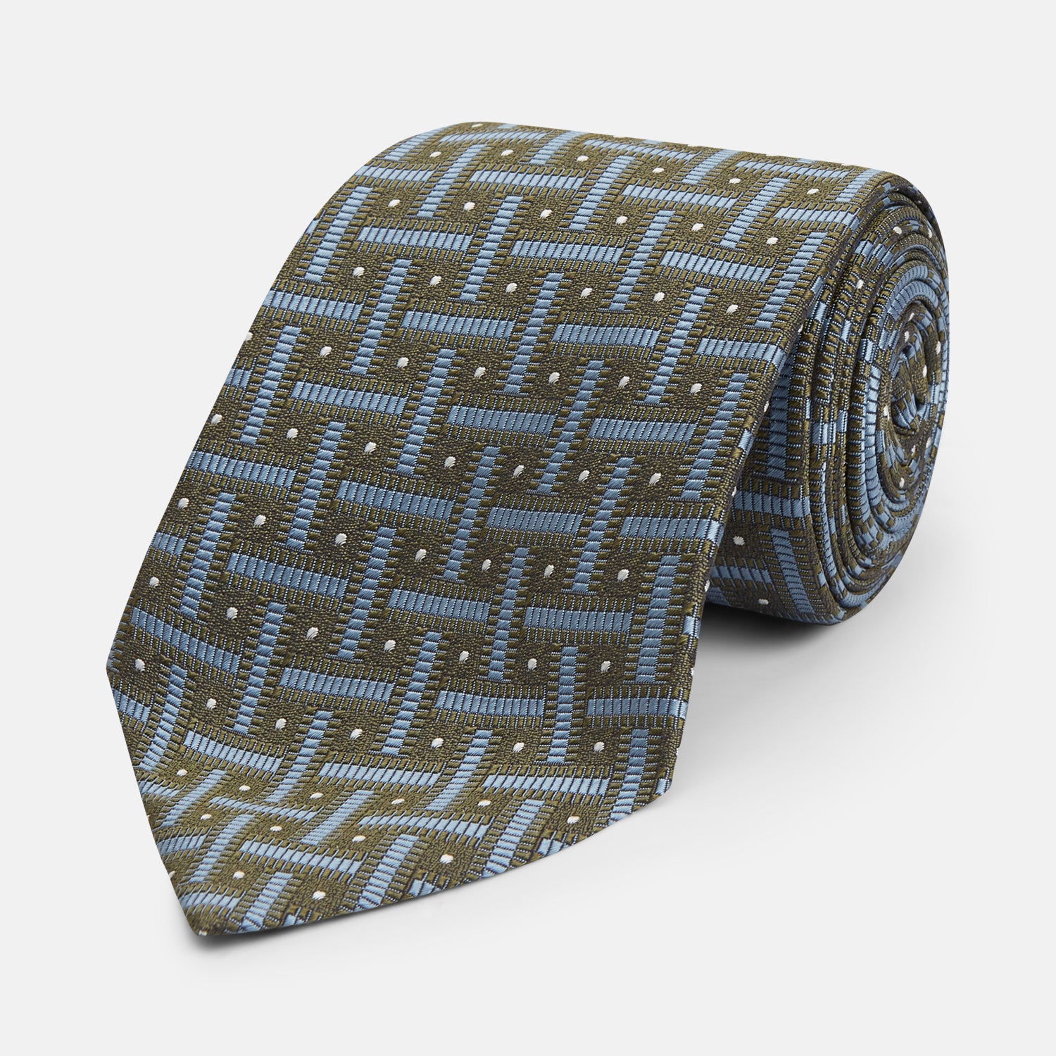 View 1 of product The Turnbull & Asser Green & Navy Cross Silk Tie features an olive green base with navy geometric patterns and white dots, shown rolled on a light surface—an ideal accessory to elevate any formal look.