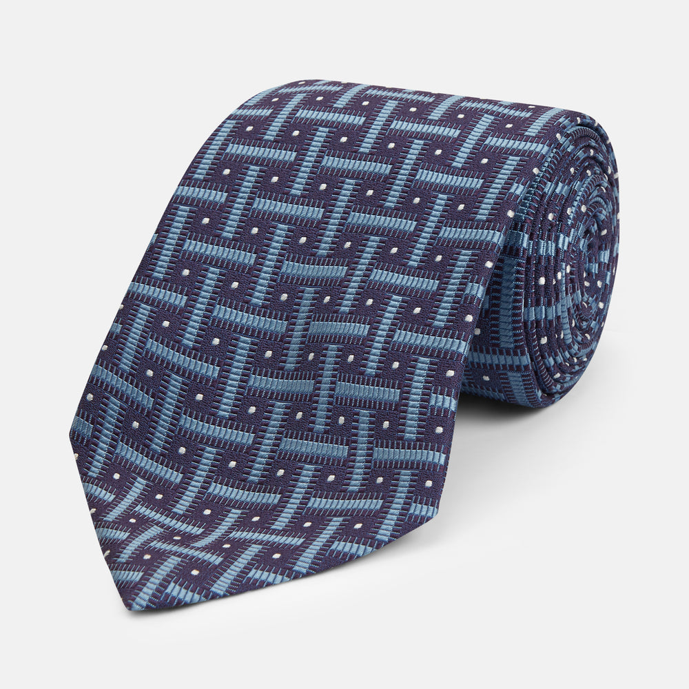 The Turnbull & Asser Navy & Blue Cross Silk Tie features a navy silk base with light blue and white geometric patterns and small white dots—ideal for elevating formal looks or pairing with signature shirts.