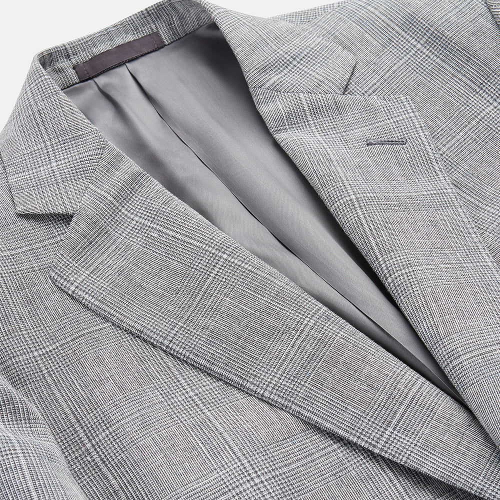 The Turnbull & Asser Grey Multi Check Linen Blend Barrington Blazer features notched lapels, a two-button single-breasted front, flap pockets, and buttoned cuffs, shown against a plain white background.