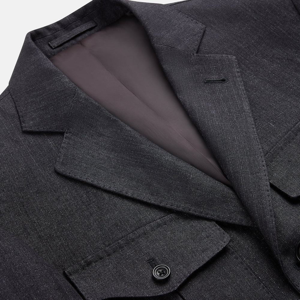 The Turnbull & Asser Charcoal Linen Safari Byron Jacket has a contemporary fit, notched lapel, front button closure, and four flap pockets—two chest and two waist—shown on a plain white background.