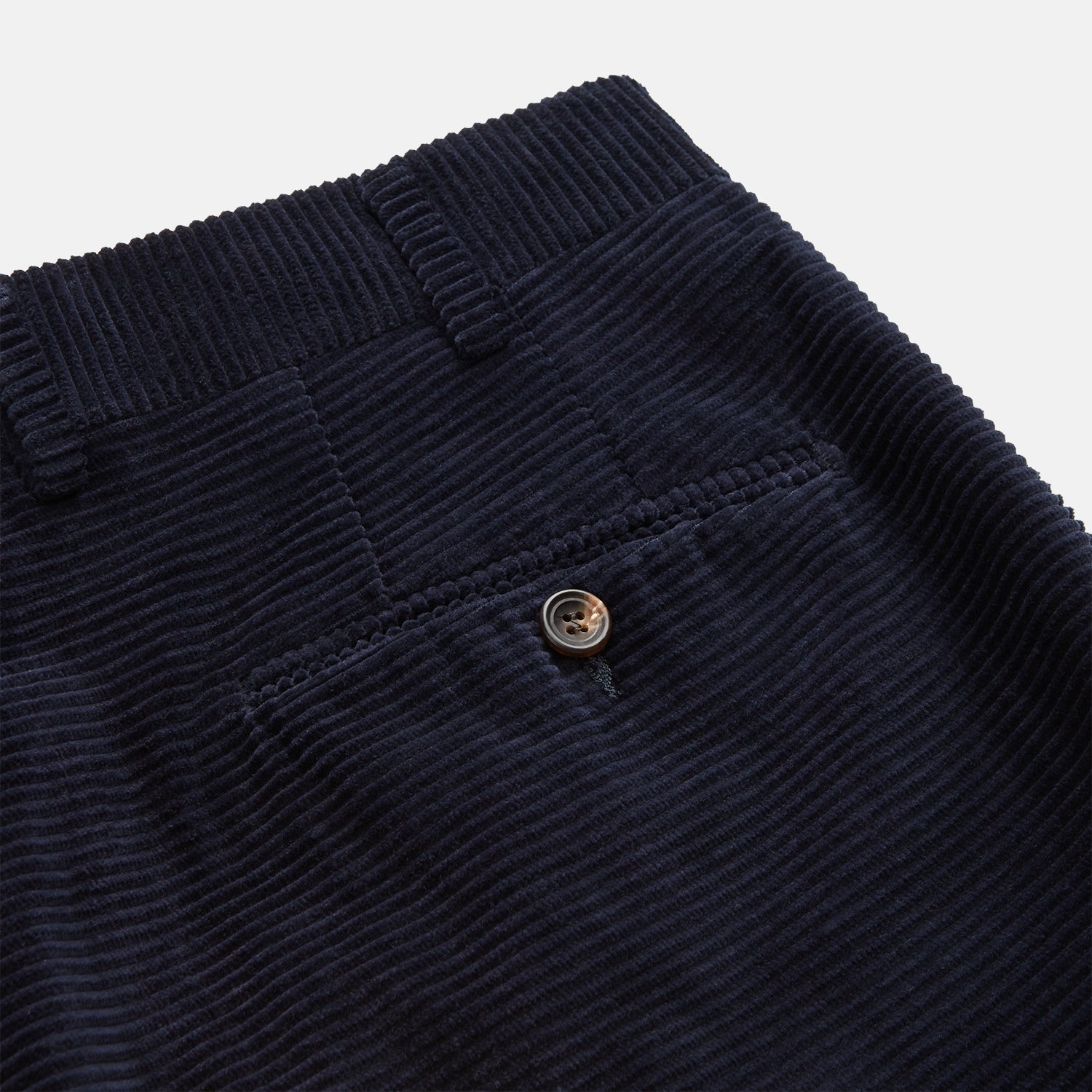View 3 of product A pair of Turnbull & Asser Navy Horizontal Cord Nolan Trousers featuring a straight-leg fit, button and zip closure, front pleats, and classic horizontal cord texture, laid flat on a white background.
