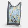 View 3 of product The Pale Blue Wool and Cashmere Lily Blanket by Turnbull & Asser features abstract, hand-drawn designs in blue, yellow, and gray on a white background.