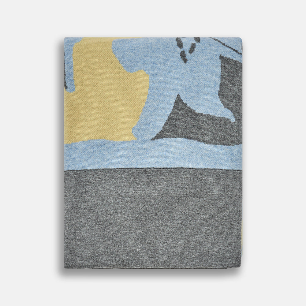 The Pale Blue Wool and Cashmere Lily Blanket by Turnbull & Asser features abstract, hand-drawn designs in blue, yellow, and gray on a white background.