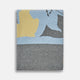 The Pale Blue Wool and Cashmere Lily Blanket by Turnbull & Asser features abstract, hand-drawn designs in blue, yellow, and gray on a white background.