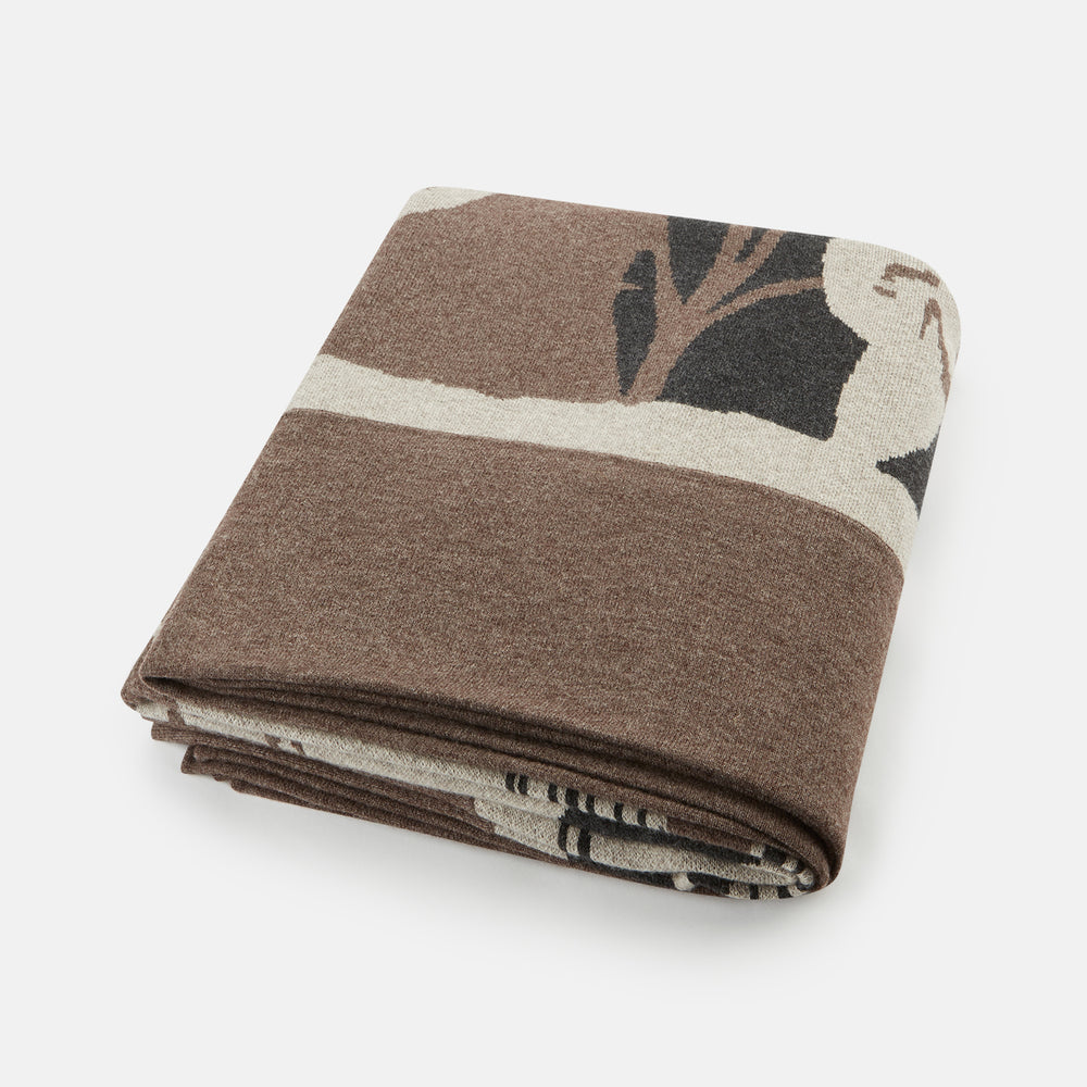 The Grey Wool And Cashmere Lily Blanket by Turnbull & Asser features an abstract animal outline in brown, beige, and dark grey on white. Expertly hand-finished, this folded blanket blends wool and cashmere for a luxurious touch.