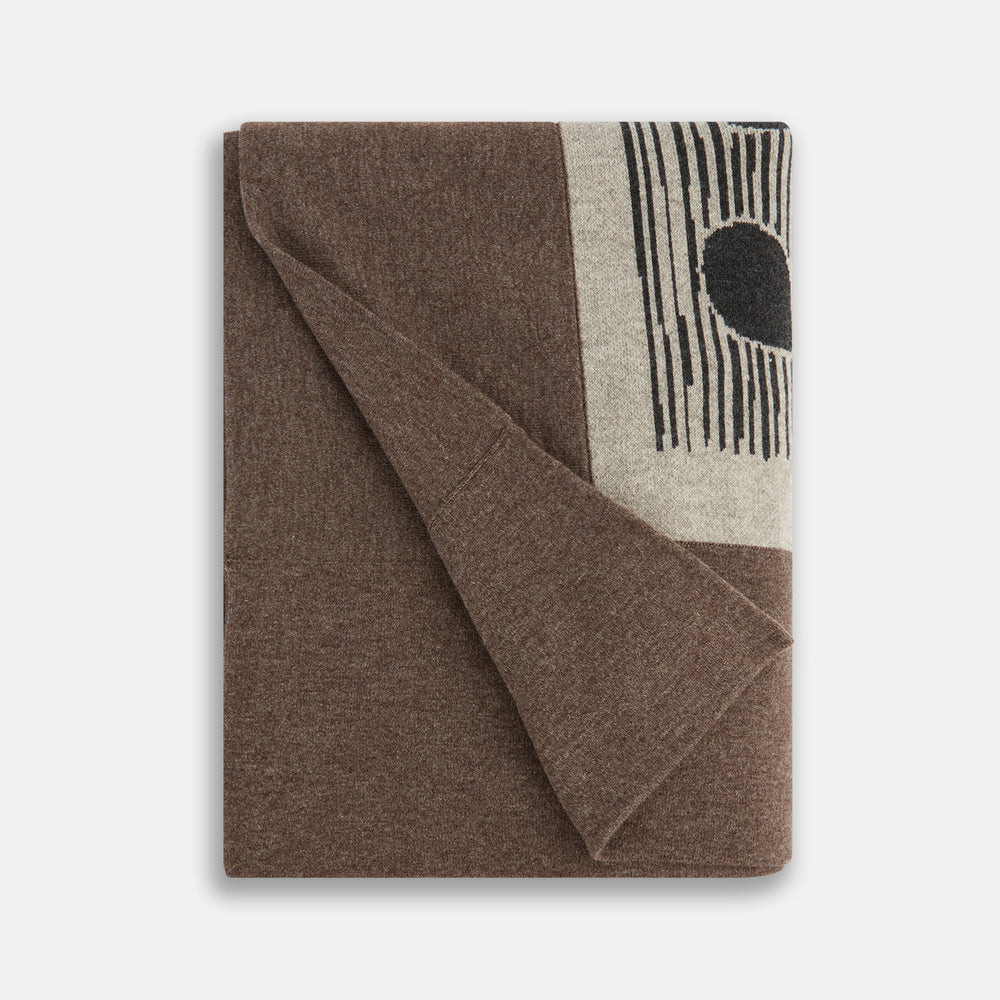 The Grey Wool And Cashmere Lily Blanket by Turnbull & Asser features an abstract animal outline in brown, beige, and dark grey on white. Expertly hand-finished, this folded blanket blends wool and cashmere for a luxurious touch.