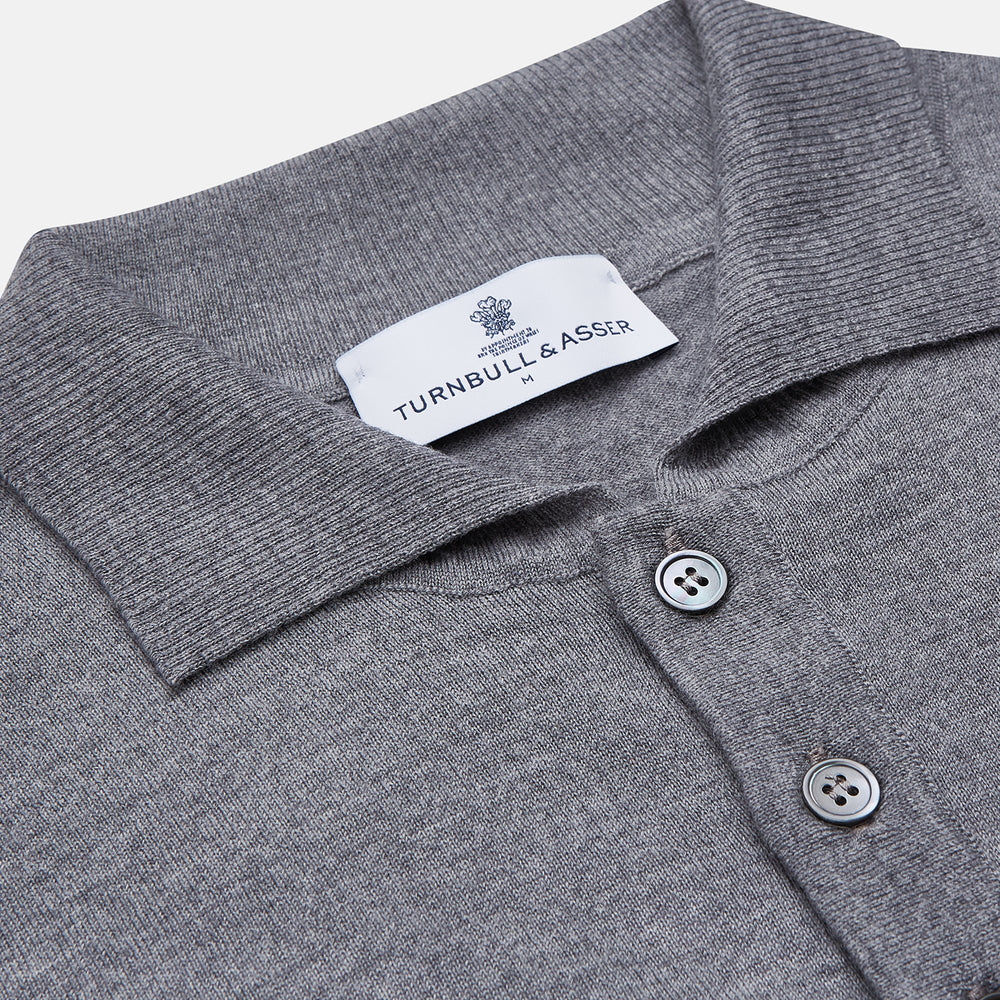 The Grey Merino Wool Cecil Rugby Polo Shirt by Turnbull & Asser features long sleeves, a collar, three-button placket, and ribbed hem and cuffs—an elevated menswear staple shown flat on a white background.