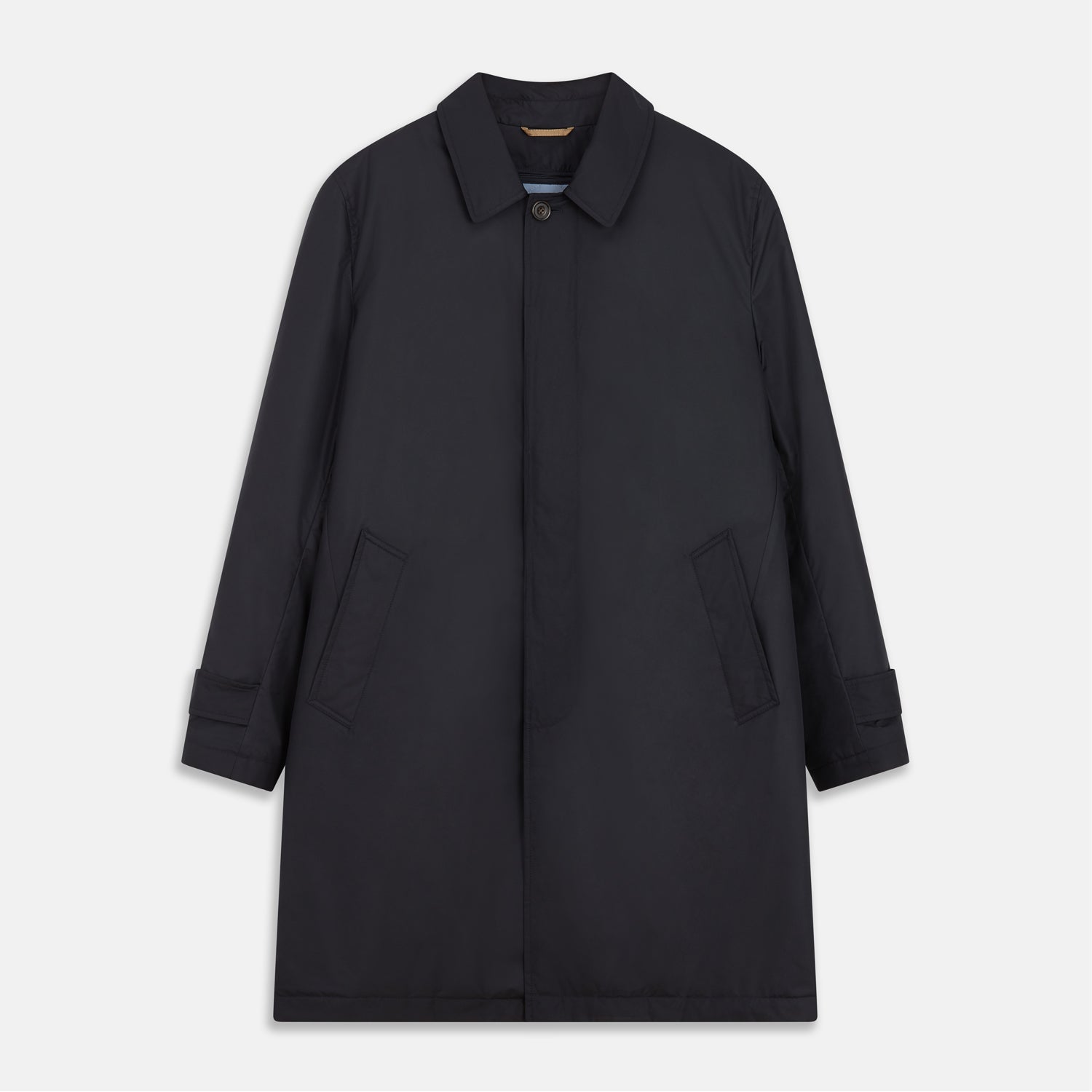 View 2 of product A man with brown hair stands outdoors, hands in his pockets, wearing a Turnbull & Asser Navy Sealup Quilted Liner Quintern Car Coat over a mustard cardigan. A glass barrier and blurred background are behind him.