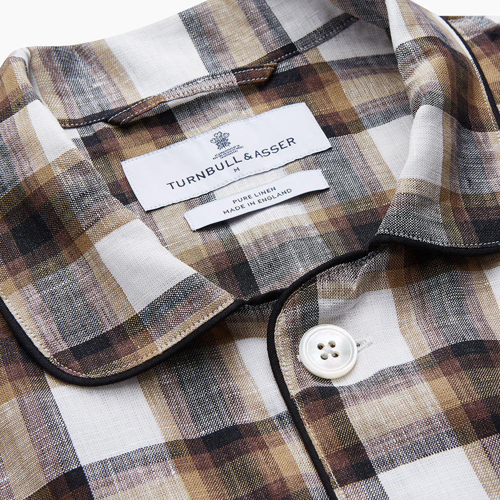 The Turnbull & Asser Brown Multi Check Linen Hyde Pyjama Set features a button-up, long-sleeve top and pants with a brown, black, and white plaid pattern, shown on a white background.