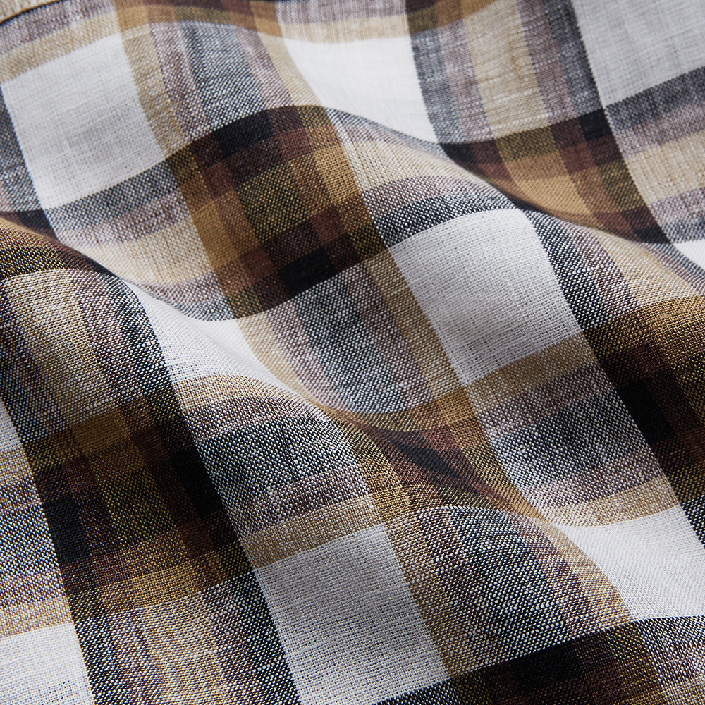 The Turnbull & Asser Brown Multi Check Linen Hyde Pyjama Set features a button-up, long-sleeve top and pants with a brown, black, and white plaid pattern, shown on a white background.