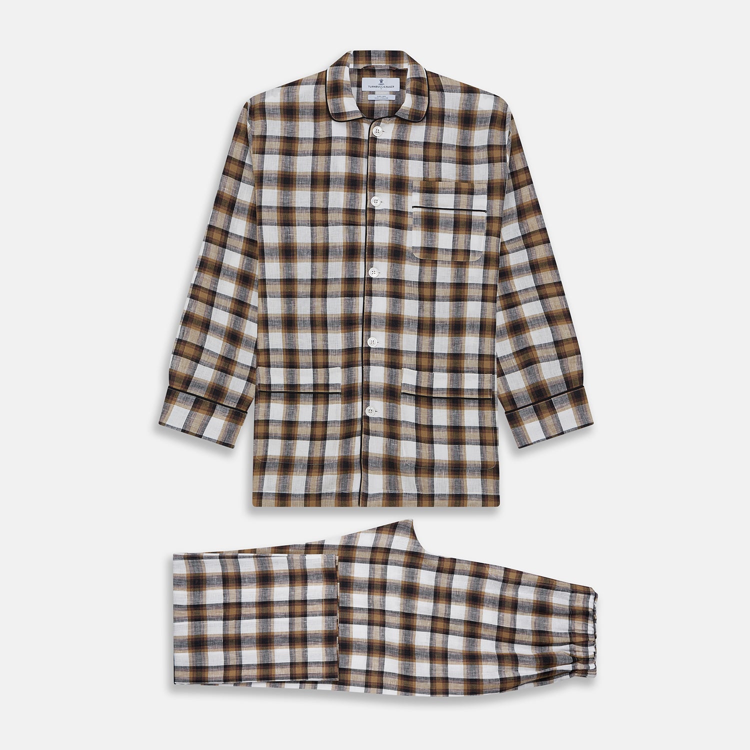 View 1 of product The Turnbull & Asser Brown Multi Check Linen Hyde Pyjama Set features a button-up, long-sleeve top and pants with a brown, black, and white plaid pattern, shown on a white background.