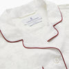 View 3 of product The Cream Floral Pattern Silk Harriet Women's Pyjama Set by Turnbull & Asser features long sleeves, pants, dark piping, a chest pocket, and luxurious silk fabric with a cream floral design, shown on a plain white background.