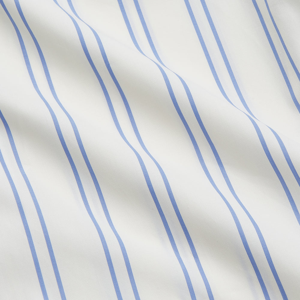The Turnbull & Asser Women's Blue Multi Cotton Thelma Pyjama Set features a long-sleeve button-up shirt with collar and pocket, plus matching drawstring pants, elegantly displayed against a white background.