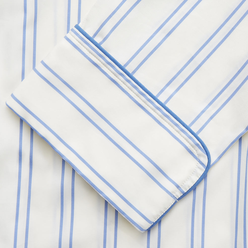 The Turnbull & Asser Women's Blue Multi Cotton Thelma Pyjama Set features a long-sleeve button-up shirt with collar and pocket, plus matching drawstring pants, elegantly displayed against a white background.