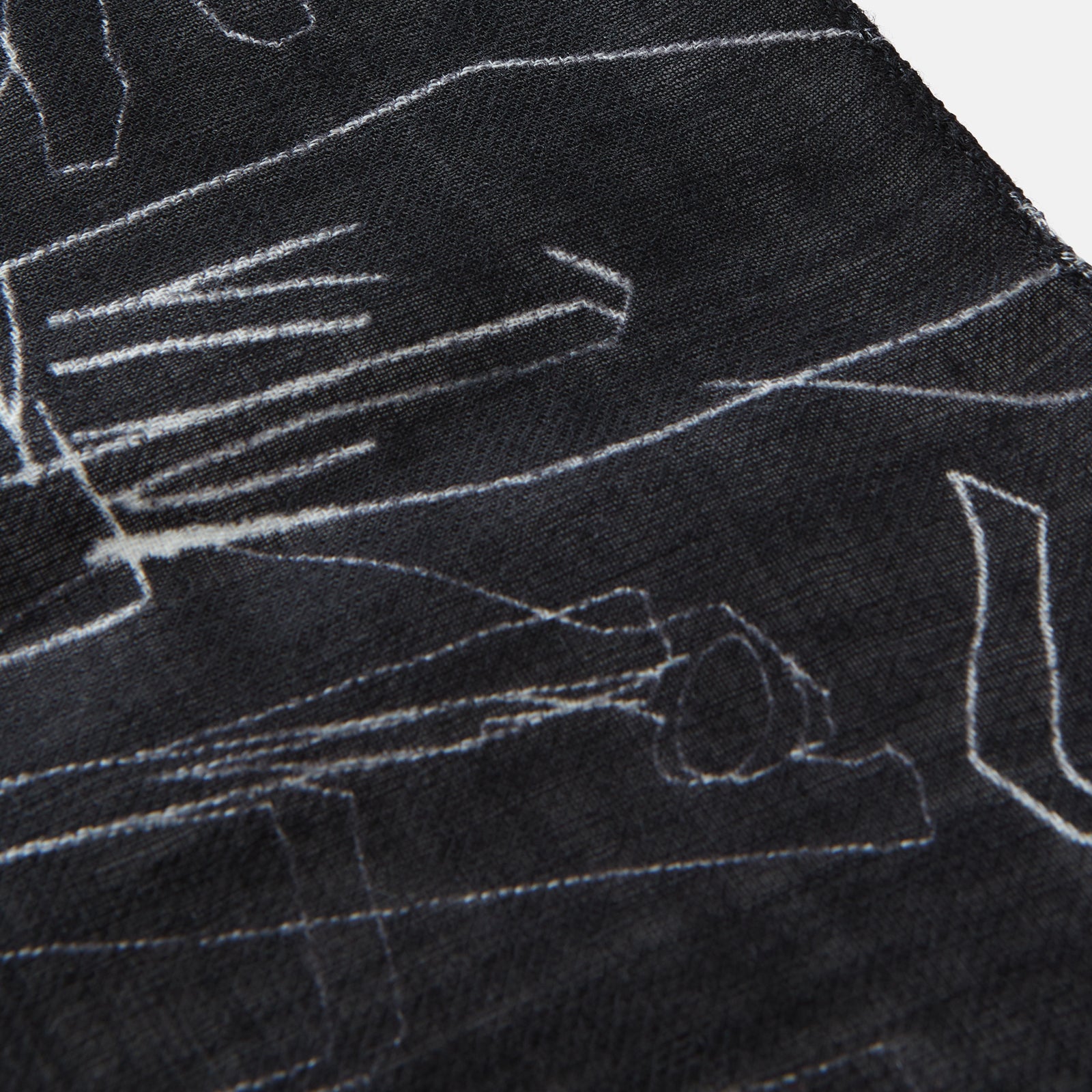 View 3 of product The Turnbull & Asser Black Sketched Pattern Wool Chilcott Scarf features white abstract lines, frayed edges, and is shown loosely knotted on a light gray background.