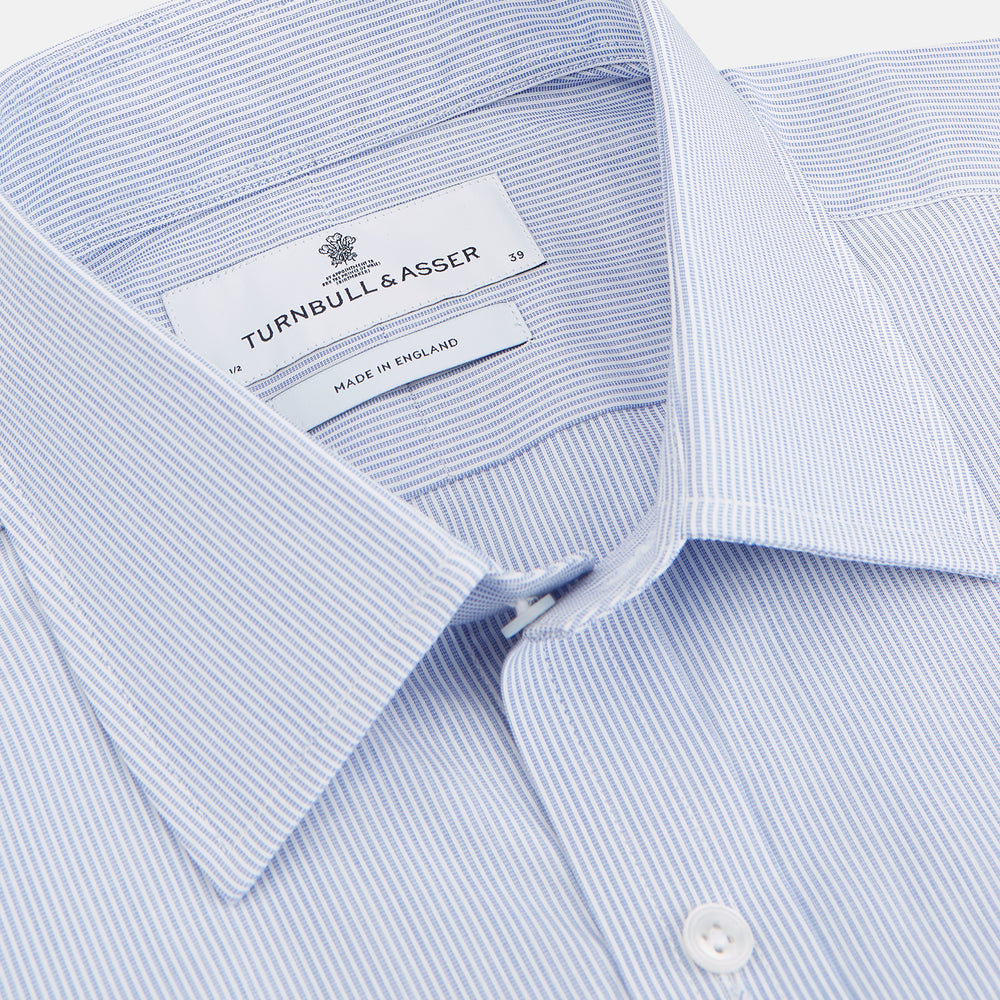 The Turnbull & Asser Blue and White Stripe Cotton Regular Fit Mayfair Shirt features long sleeves, a T&A collar, white buttons, and buttoned cuffs, displayed flat on a white background.