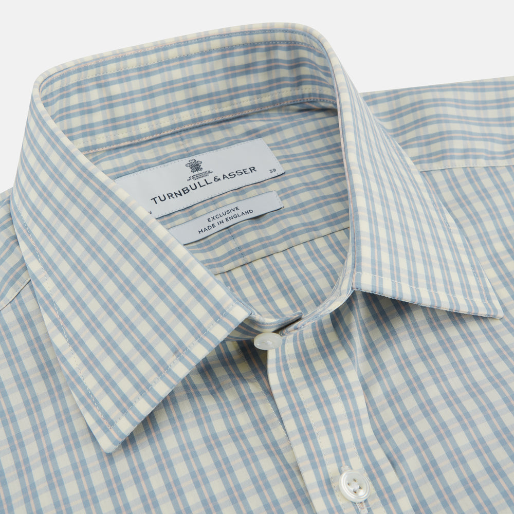 The Turnbull & Asser Pale Blue Multi Check Cotton Regular Fit Mayfair Shirt features long sleeves and a button-up front, displayed against a plain white background.