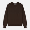 View 1 of product The Turnbull & Asser Brown Cashmere Glenn Jumper is a classic menswear piece with a crew neck and ribbed cuffs, collar, and hem. It’s laid flat on a white background, showcasing its timeless long-sleeved design.