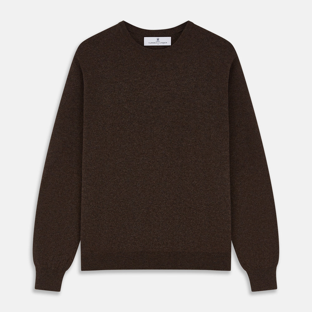 The Turnbull & Asser Brown Cashmere Glenn Jumper is a classic menswear piece with a crew neck and ribbed cuffs, collar, and hem. It’s laid flat on a white background, showcasing its timeless long-sleeved design.