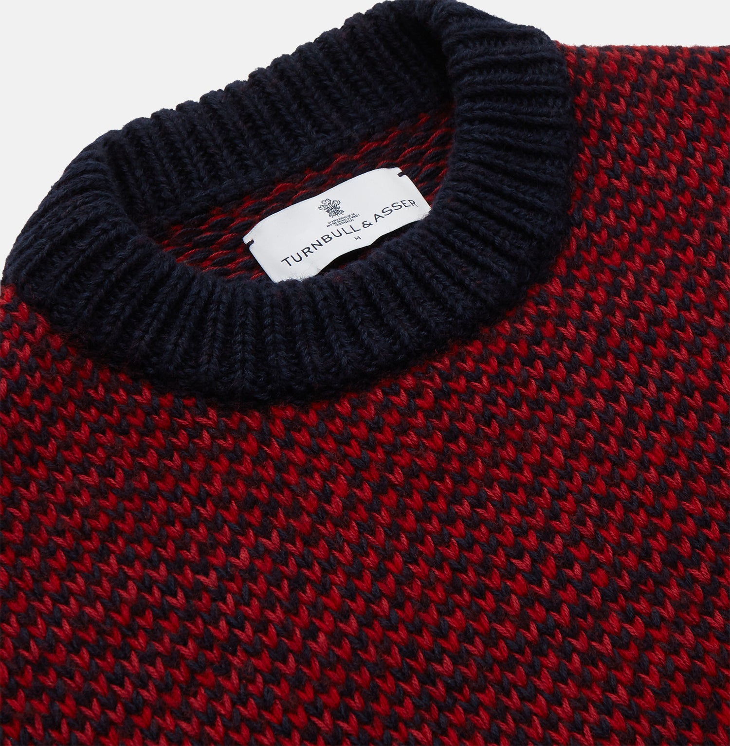 View 2 of product The Turnbull & Asser Red and Navy Wool Blend Billy Jumper features a red knit body with navy ribbed collar, cuffs, and hem, made from a wool and cotton blend, shown on a white background.