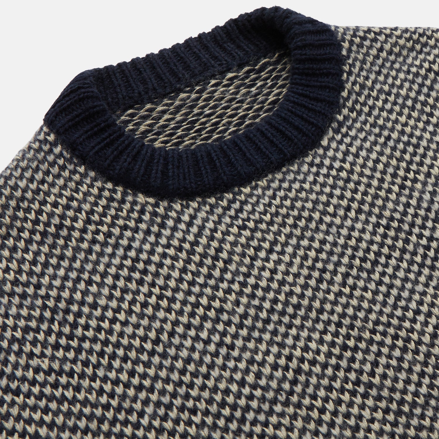 View 2 of product The Turnbull & Asser Navy and White Wool Blend Billy Jumper features a small checkered pattern with ribbed black collar, cuffs, and hem. Shown laid flat on a white background.
