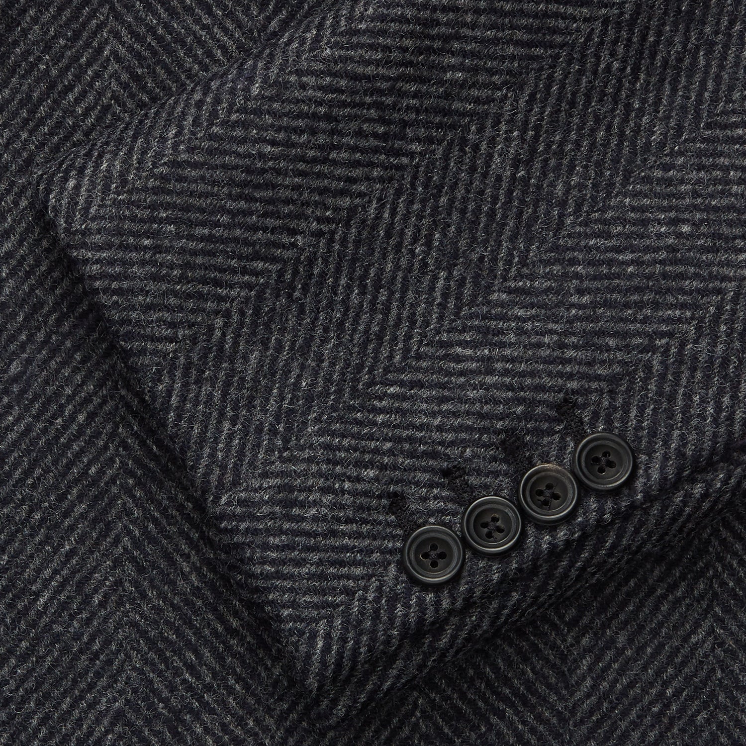 View 2 of product The Grey Herringbone Wool Double Breasted Highgrove Overcoat by Turnbull & Asser features black buttons, a notched lapel, and side pockets, shown against a plain white background.