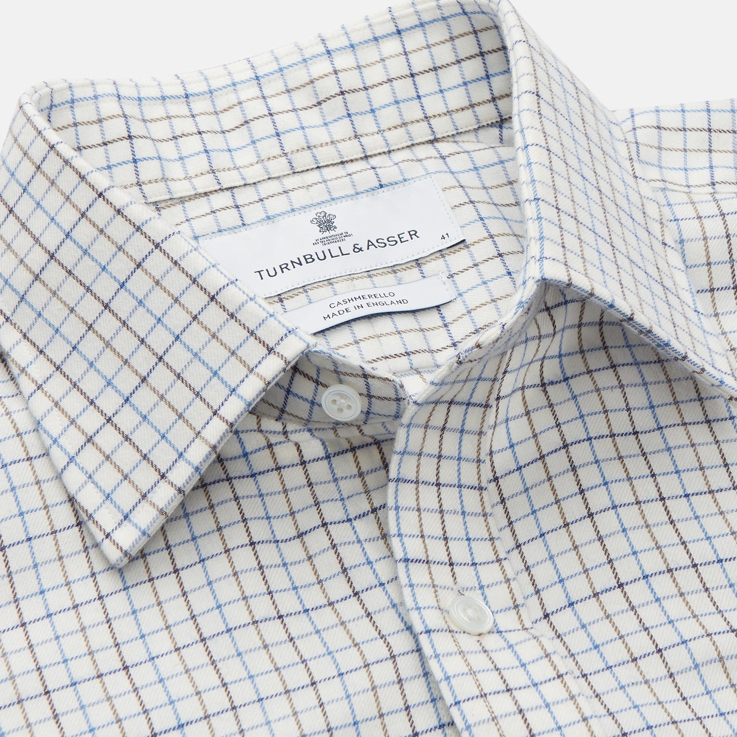 View 3 of product The Turnbull & Asser Blue Tattersall Check Cashmerello Regular Fit Mayfair Shirt is a long-sleeve button-up with a collar and chest pocket, featuring a white base and blue checks, shown laid flat on a white background.