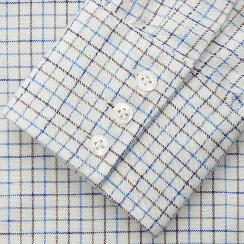 The Turnbull & Asser Blue Tattersall Check Cashmerello Regular Fit Mayfair Shirt is a long-sleeve button-up with a collar and chest pocket, featuring a white base and blue checks, shown laid flat on a white background.