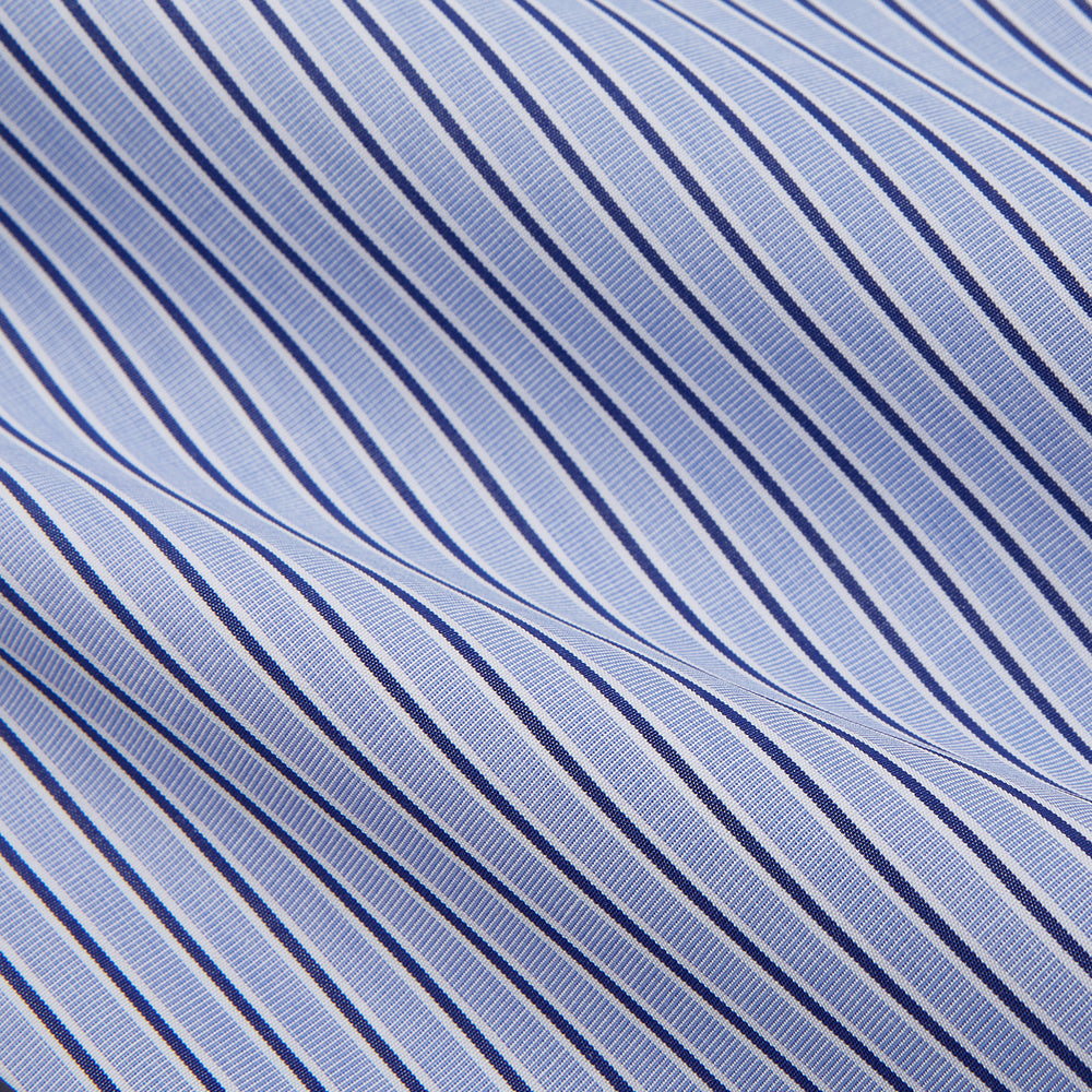 The Blue and Navy Halo Stripe Cotton Regular Fit Mayfair Shirt by Turnbull & Asser features classic styling with vertical stripes, a button-up front, and cuffed sleeves—an essential men's wardrobe piece.