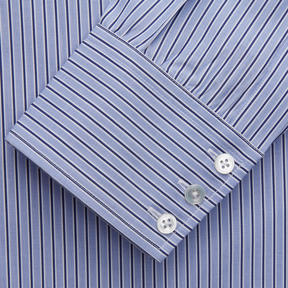 The Blue and Navy Halo Stripe Cotton Regular Fit Mayfair Shirt by Turnbull & Asser features classic styling with vertical stripes, a button-up front, and cuffed sleeves—an essential men's wardrobe piece.