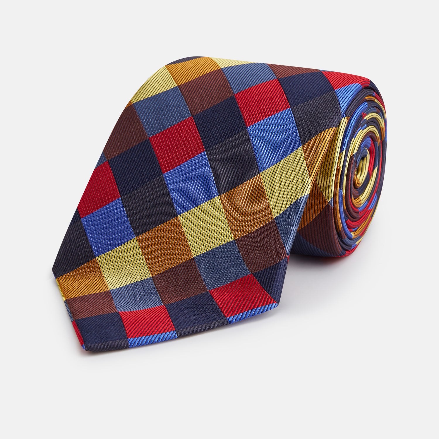 View 1 of product The Turnbull & Asser Blue, Red and Yellow Checker Silk Tie features a bold checkered pattern in red, blue, yellow, brown, and black tones, shown rolled up against a white background.