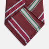 View 3 of product A Turnbull & Asser Burgundy Multi Stripe Silk Tie, featuring diagonal white, green, and blue stripes, is rolled up and displayed on a plain white background.