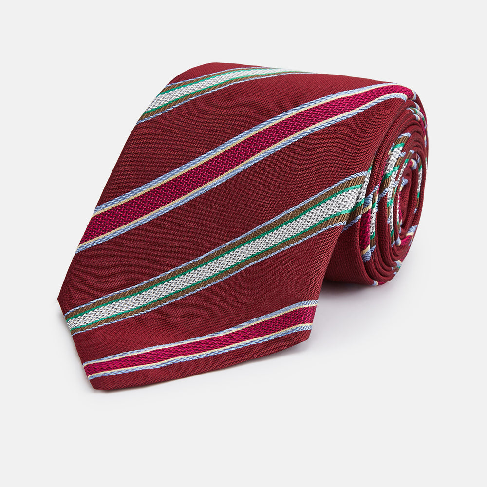 A Turnbull & Asser Burgundy Multi Stripe Silk Tie, featuring diagonal white, green, and blue stripes, is rolled up and displayed on a plain white background.