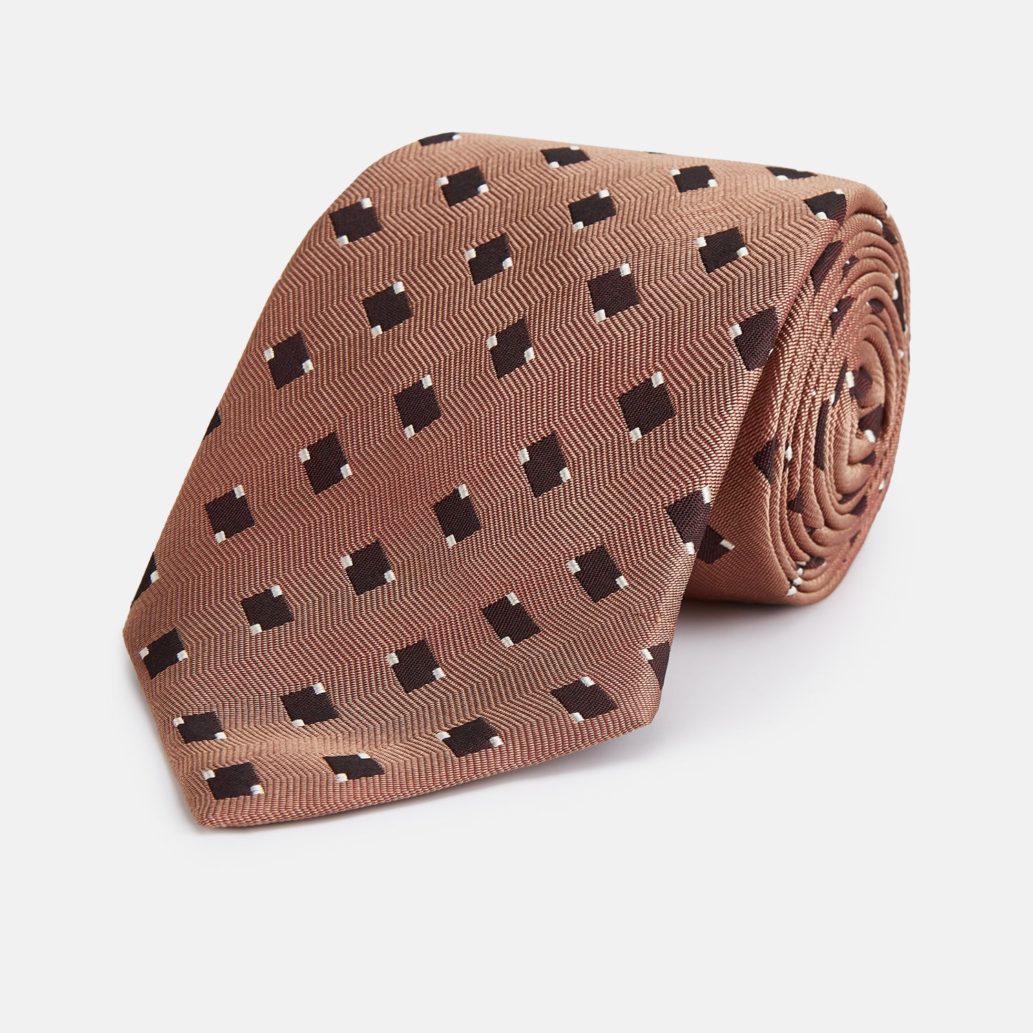 View 1 of product The Bronze and Chocolate Brown Tile Silk Tie by Turnbull & Asser features a classic tile pattern with small black graduation caps, neatly rolled on a plain white background.