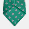View 2 of product The Turnbull & Asser Kelly Green and Grey Tile Silk Tie features a subtle chevron texture and classic grey tile pattern, displayed rolled on a white background.
