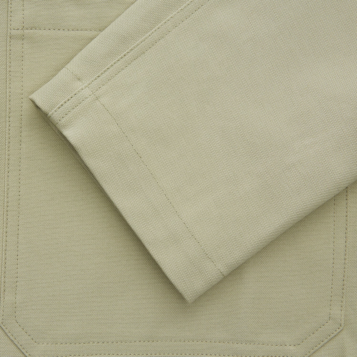 View 3 of product The Turnbull & Asser Tan Organic Cotton Blend Remy Chore Jacket features long sleeves, a collar, button-down front, and three pockets—an essential for any men’s wardrobe. The jacket is shown laid flat on a white background.