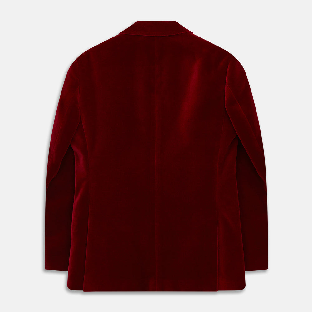 The Turnbull & Asser Wine Velvet Barrington Blazer, tailored in Italy, features a deep red hue, notched lapel, two front buttons, three pockets, and cuff button details. Shown against a plain white background.