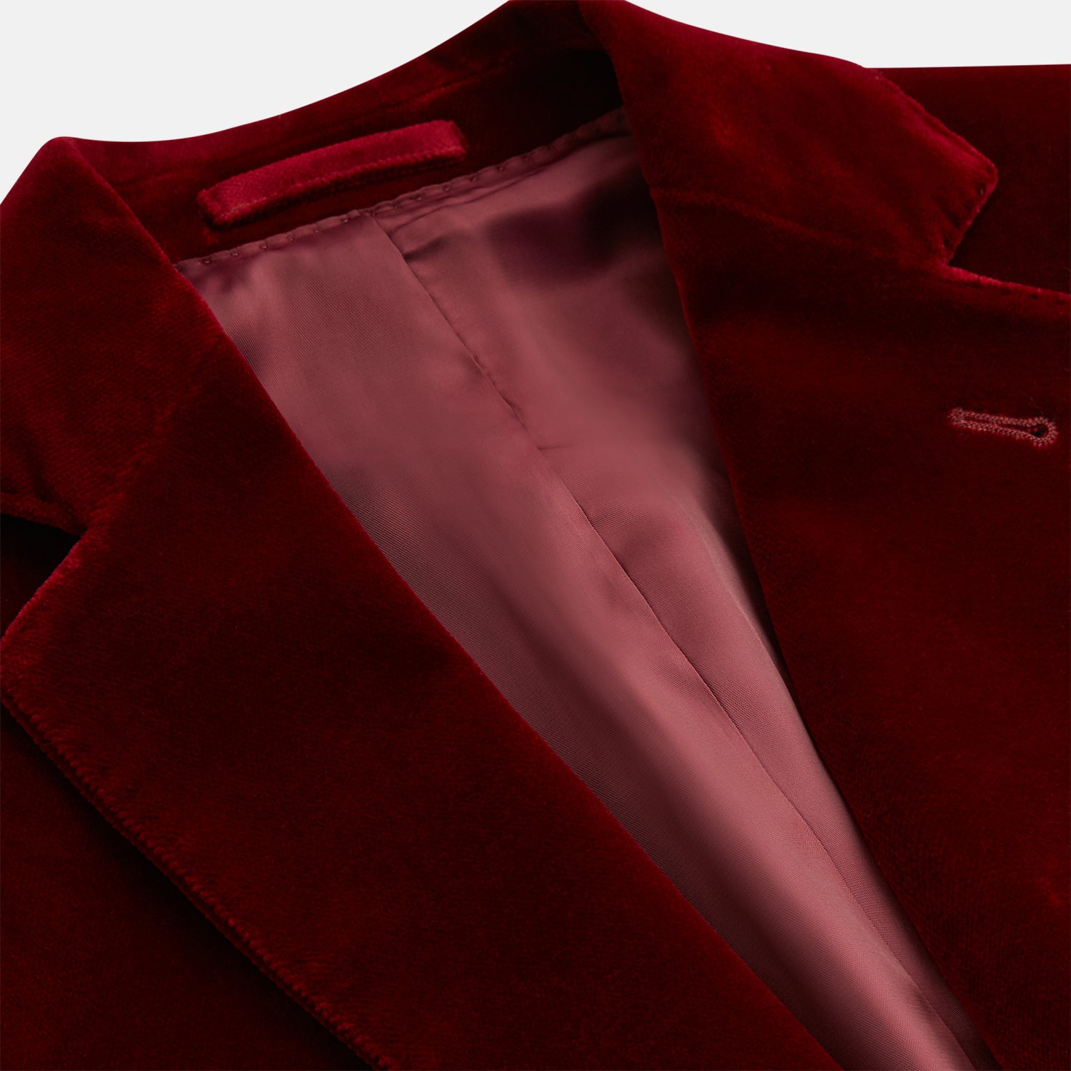 View 2 of product The Turnbull & Asser Wine Velvet Barrington Blazer, tailored in Italy, features a deep red hue, notched lapel, two front buttons, three pockets, and cuff button details. Shown against a plain white background.
