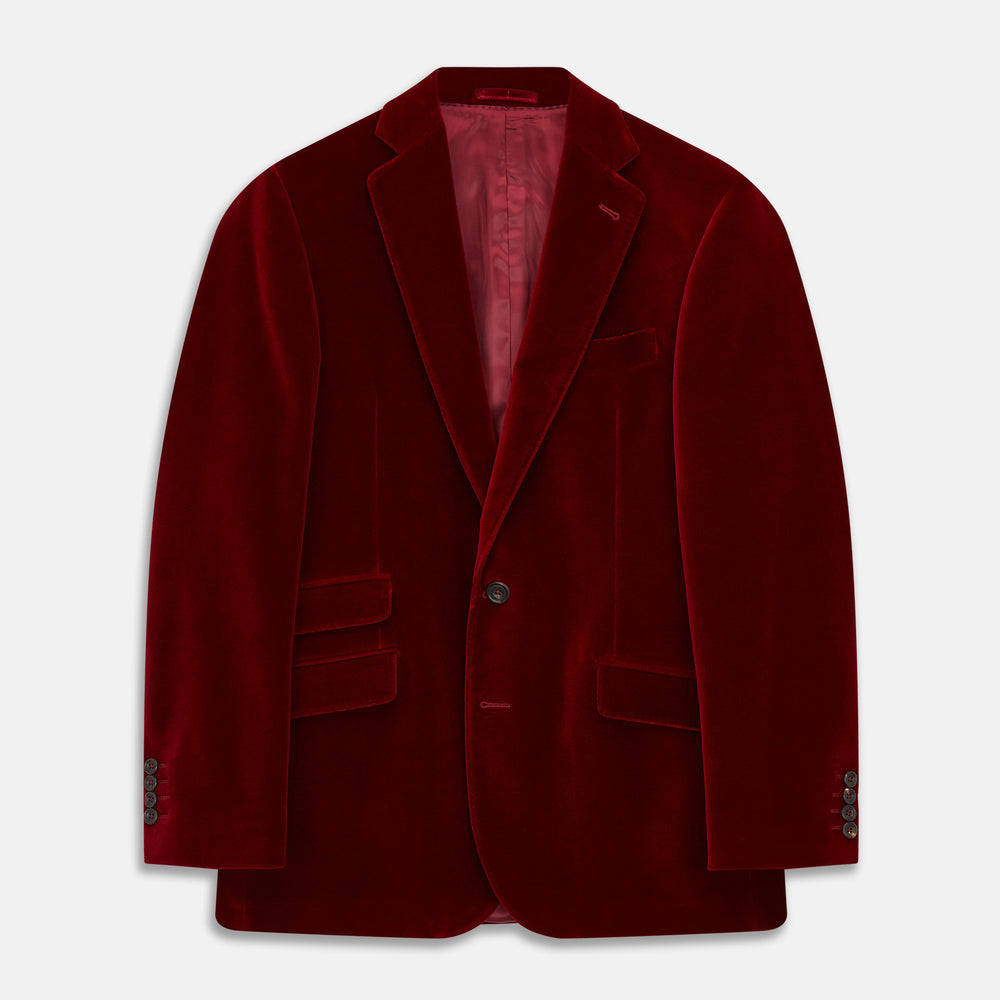 The Turnbull & Asser Wine Velvet Barrington Blazer, tailored in Italy, features a deep red hue, notched lapel, two front buttons, three pockets, and cuff button details. Shown against a plain white background.