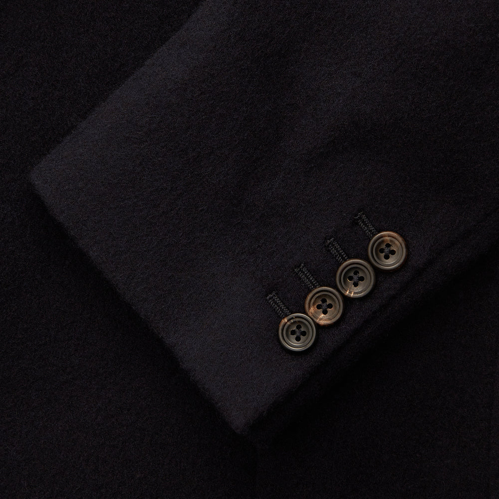 The Turnbull & Asser Navy Cashmere Bern Blazer features a notched lapel, two-button front, three front pockets, and cuff button details. Shown laid flat on a white background.